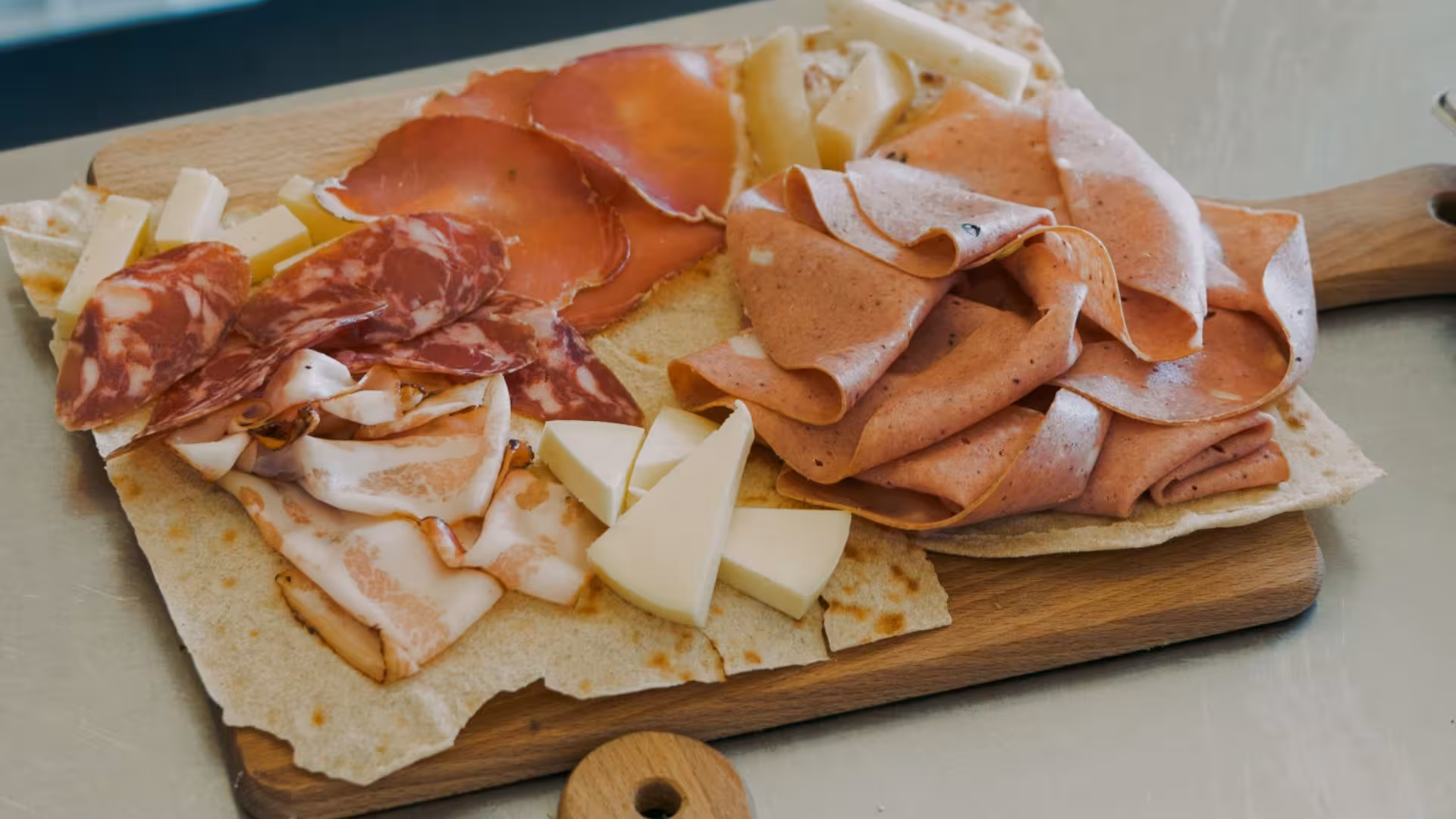 Traditional Sardinian charcuterie board with cured meats, cheeses, and flatbread, ideal for a culinary tour in Alghero.