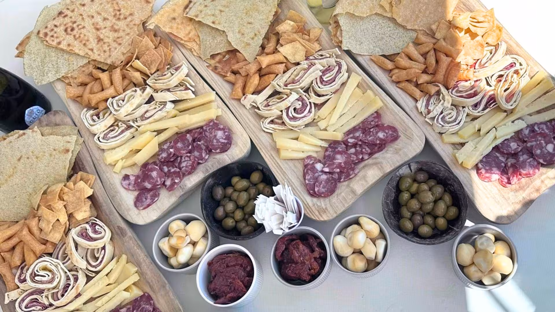 Gourmet Sardinian charcuterie board with cheeses, meats, and olives on a catamaran in La Maddalena Archipelago.