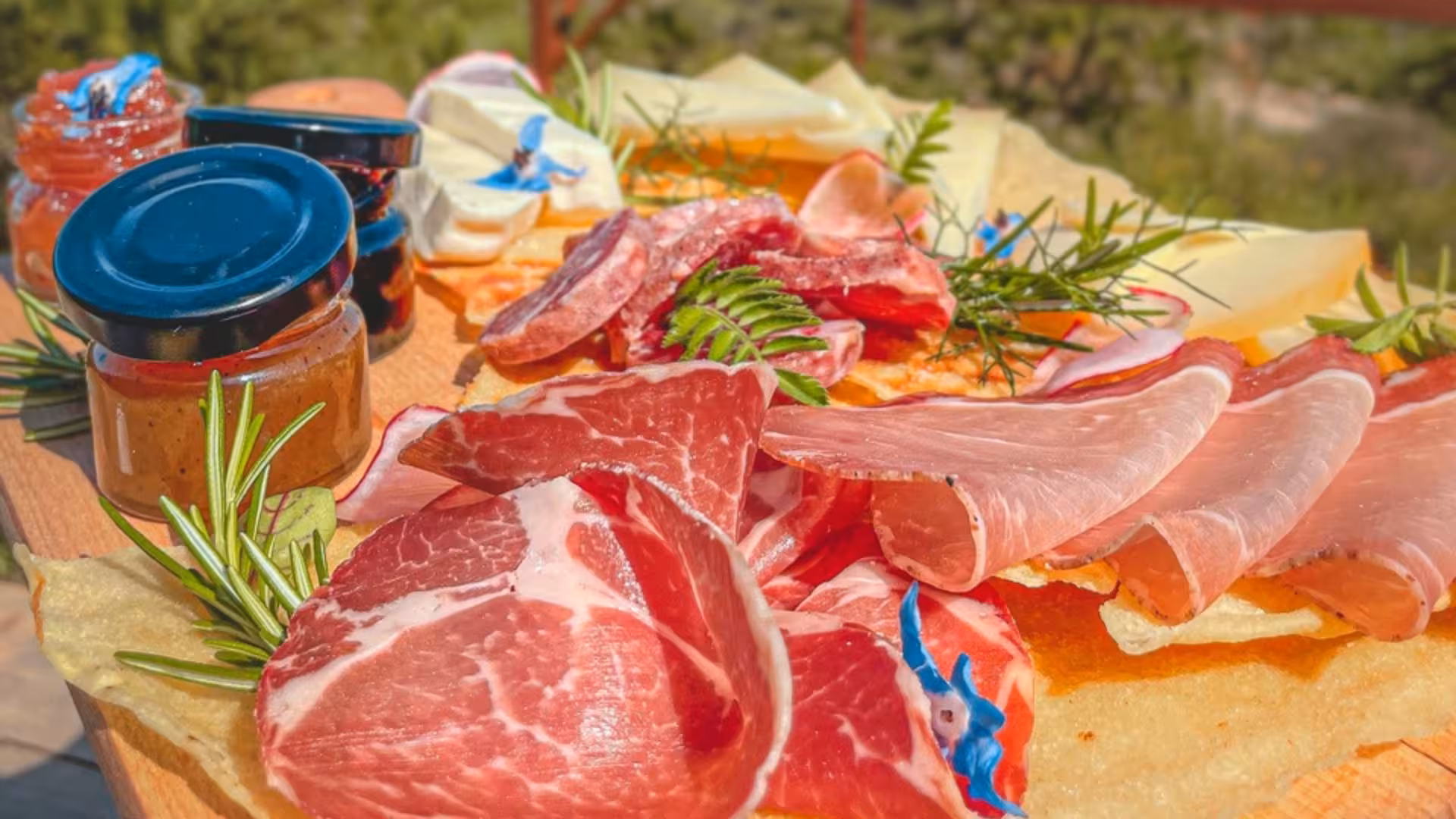 Traditional Sardinian charcuterie with cured meats and cheeses in Porto Conte Park, Alghero, Italy.