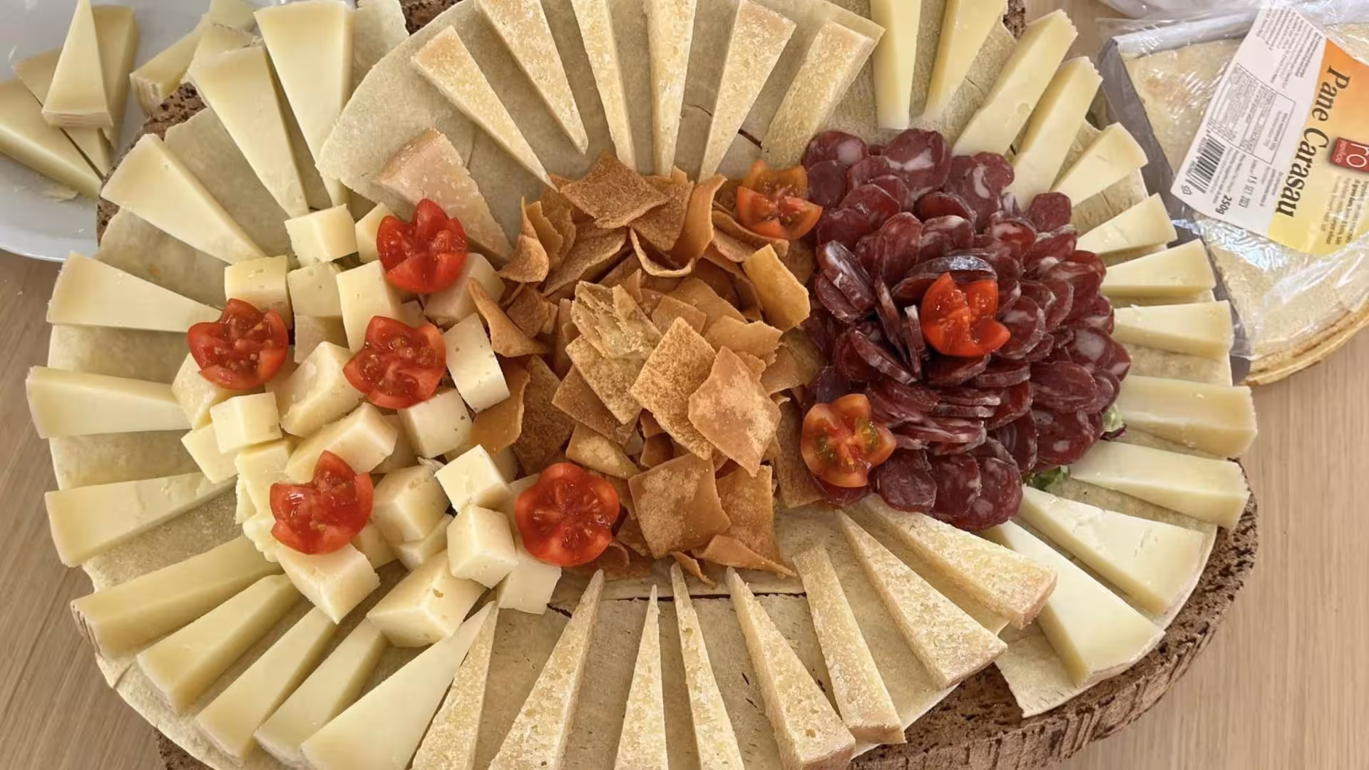 Delicious Sardinian cheese and salami platter with pane carasau, perfect for a Corsica sailing trip.
