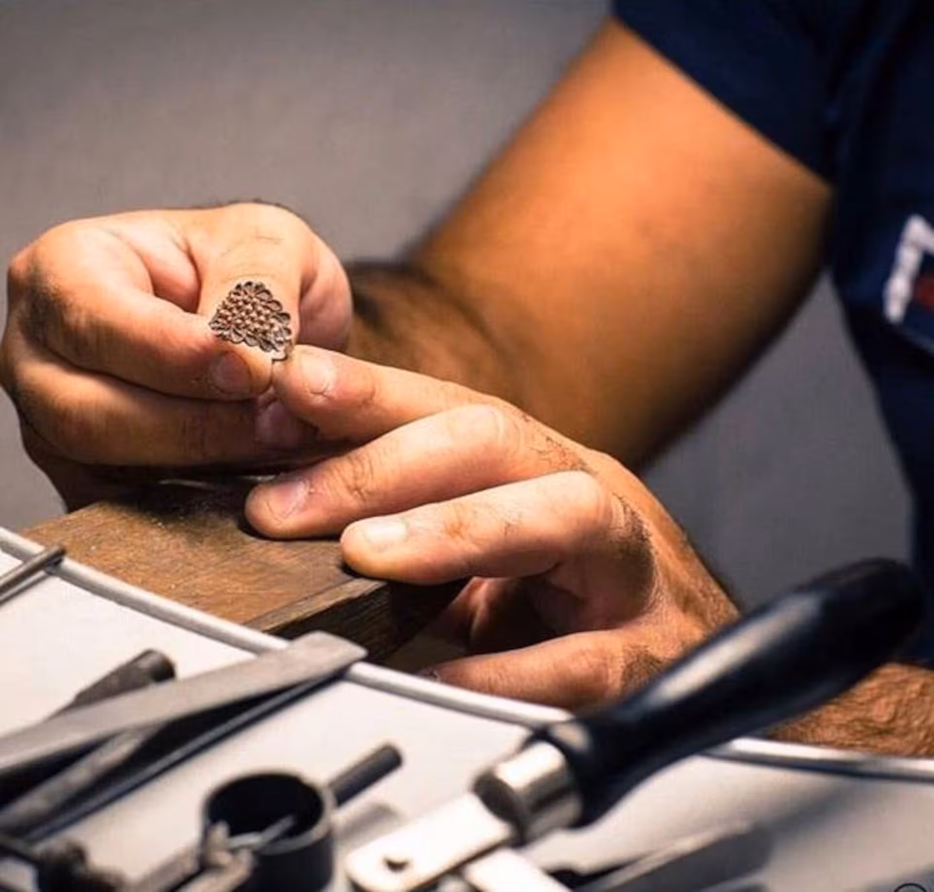 Close-up of a craftsman delicately handling a piece of Sardinian filigree in a Dorgali workshop.