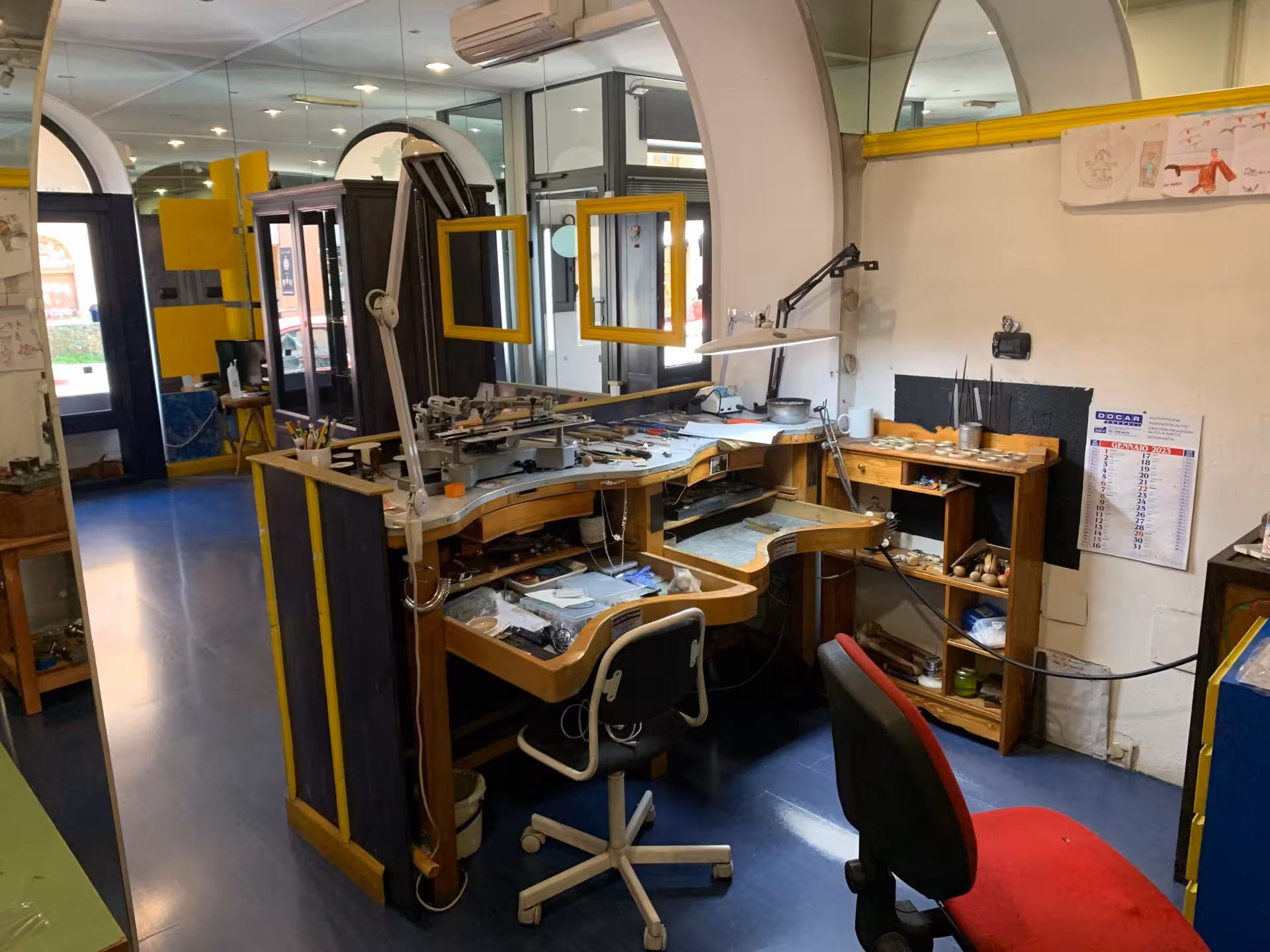 Interior view of a Sardinian filigree goldsmith's lab in Dorgali, showcasing workbenches and tools for jewelry crafting.