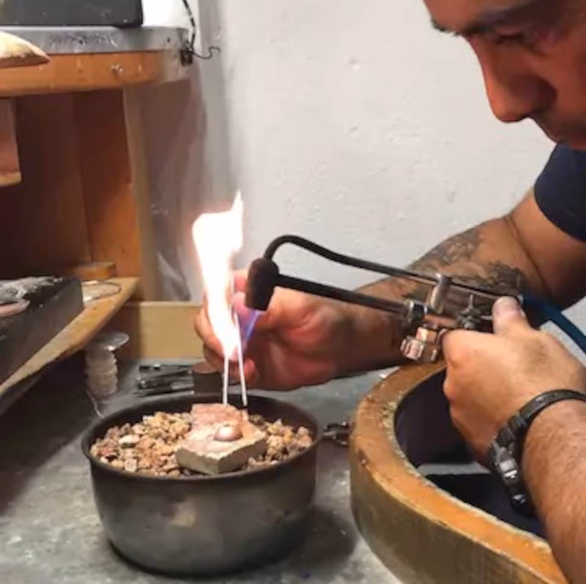 Artisan using a torch in a Sardinian filigree workshop during a Dorgali goldsmith tour experience.