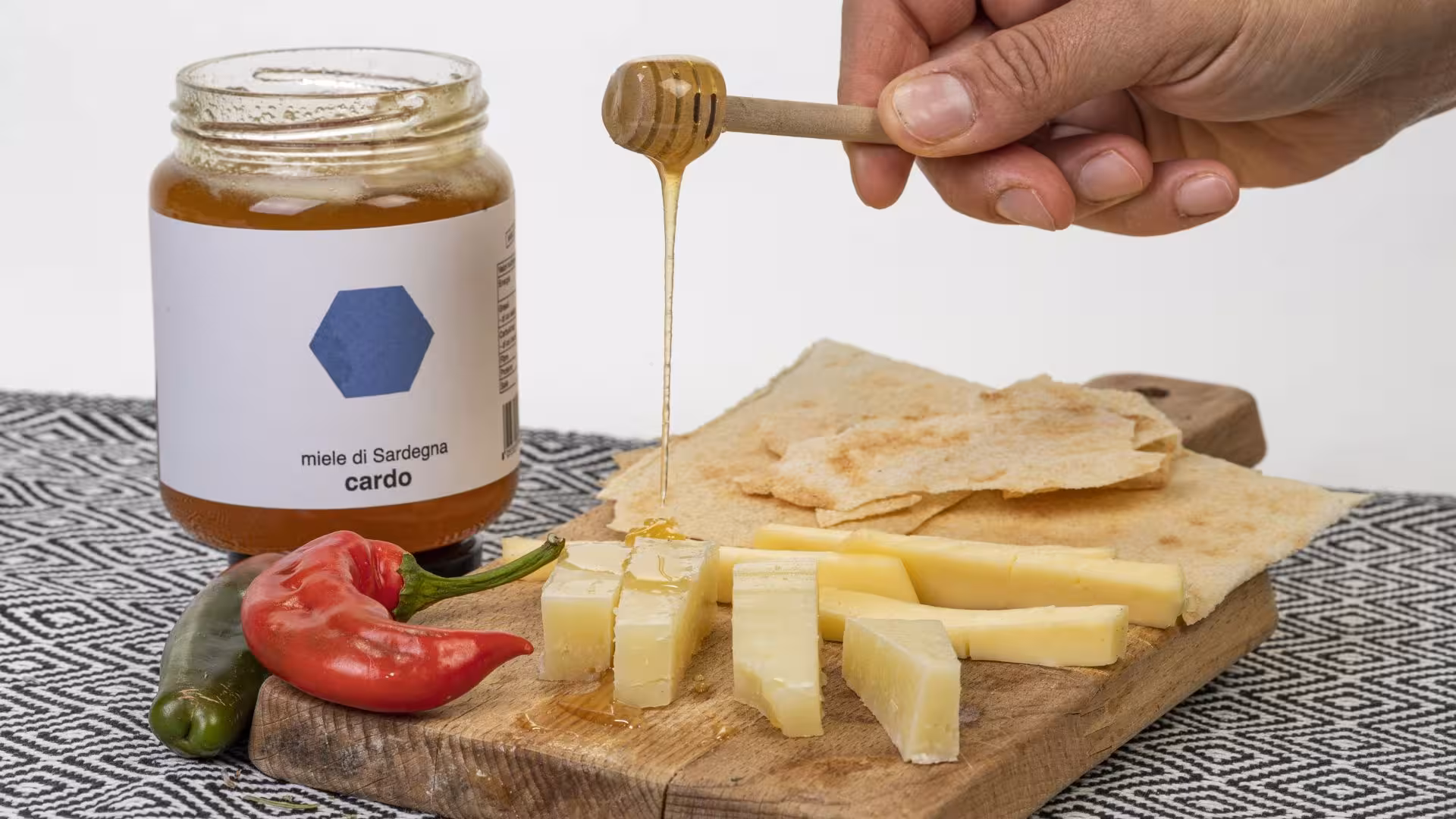 Sardinian honey being drizzled over cheese and bread, highlighting Tula's exquisite tasting experience.