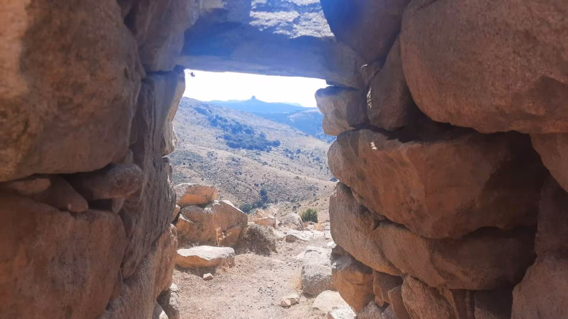 View of Sardinian landscape through a stone window in a historic building on a Barbagia Jeep tour.