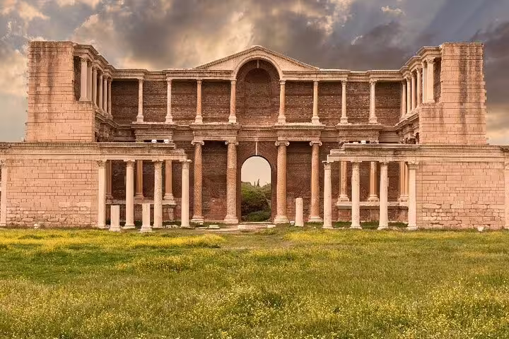 The grand ancient facade of Sardis stands majestically against a dramatic sky on the 7 Churches of Revelation Tour.
