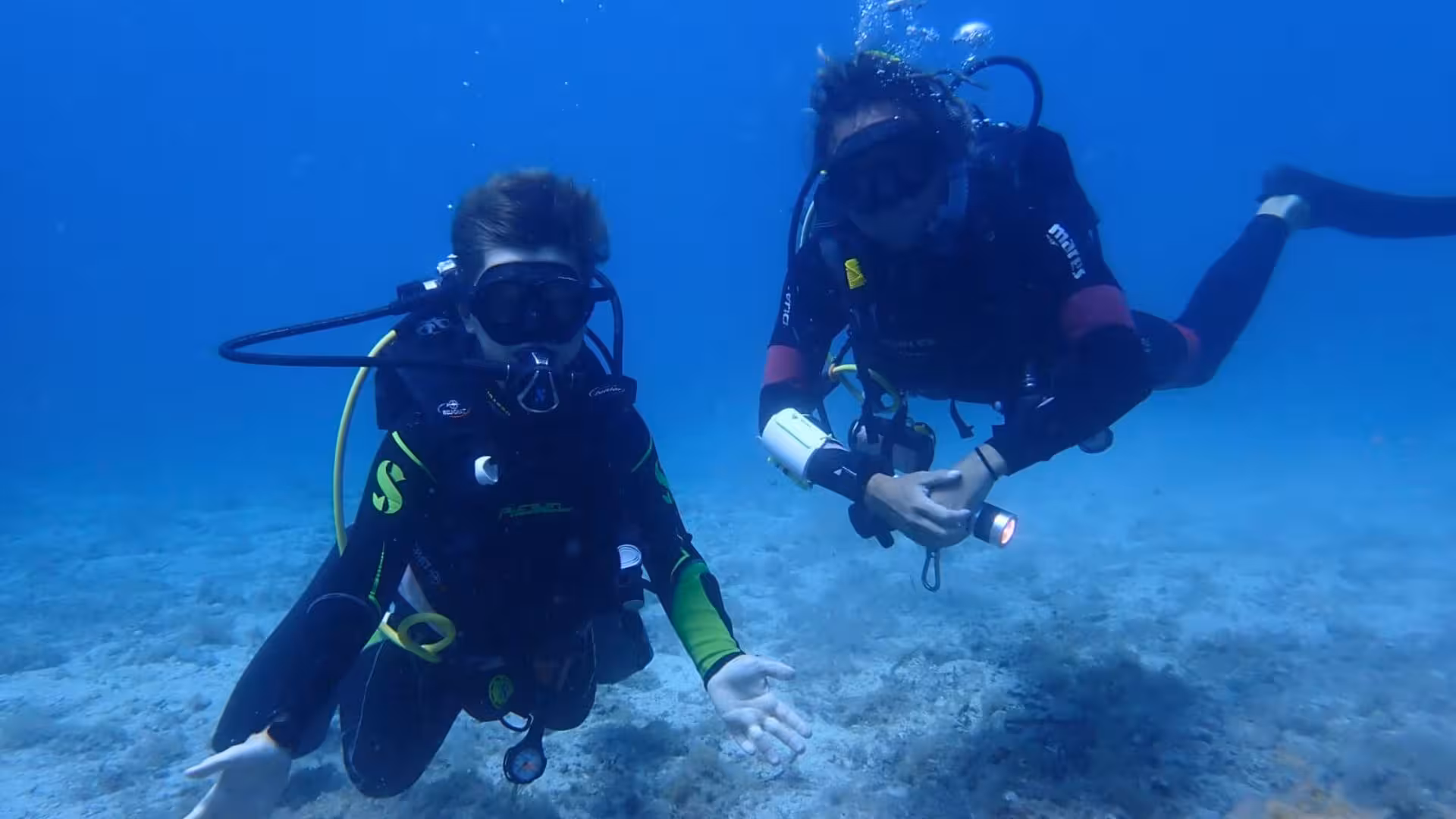 Two divers explore the vibrant underwater world of Argentiera, Sassari during an introductory scuba baptism tour.