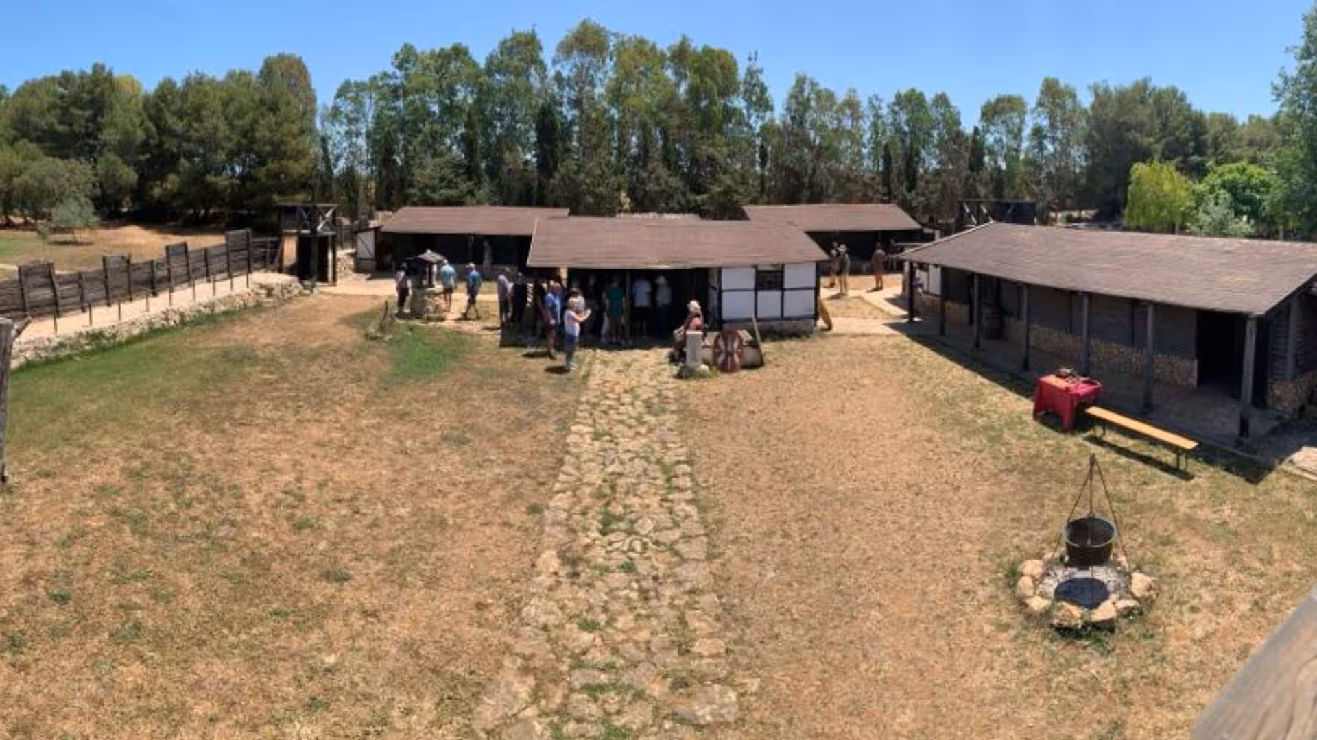 Visitors explore the Roman Castrum in Sassari with rustic buildings and educational farm activities.