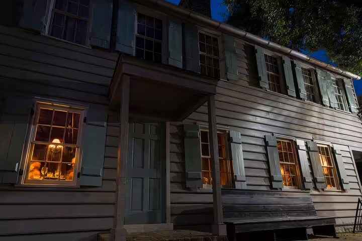 Historic colonial house at night with glowing windows and shutters in Savannah