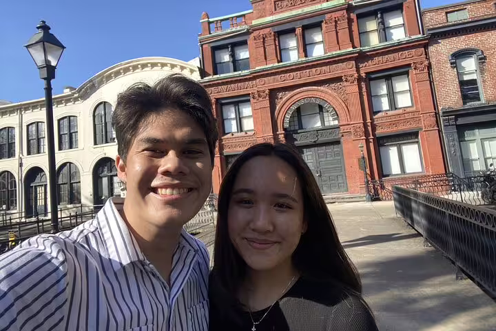 Couple smiling in selfie at Savannah Cotton Exchange building on historic waterfront