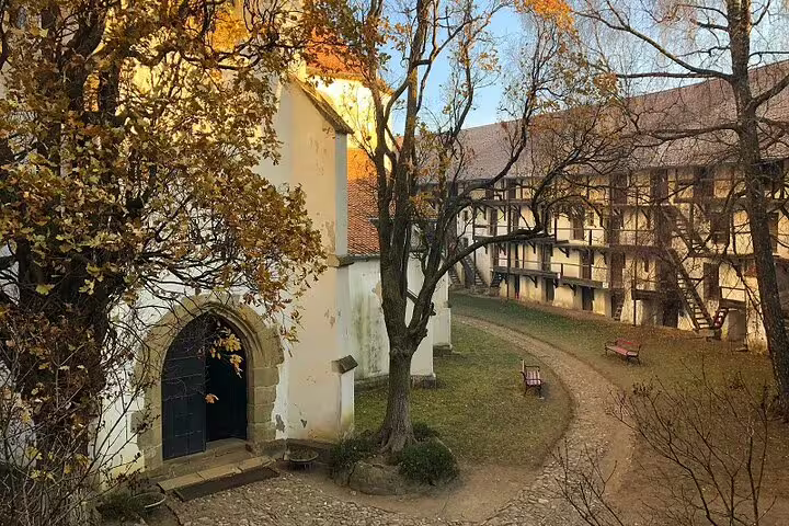 Medieval Saxon fortification courtyard with half-timbered gallery and Gothic chapel entrance in autumn, Brasov