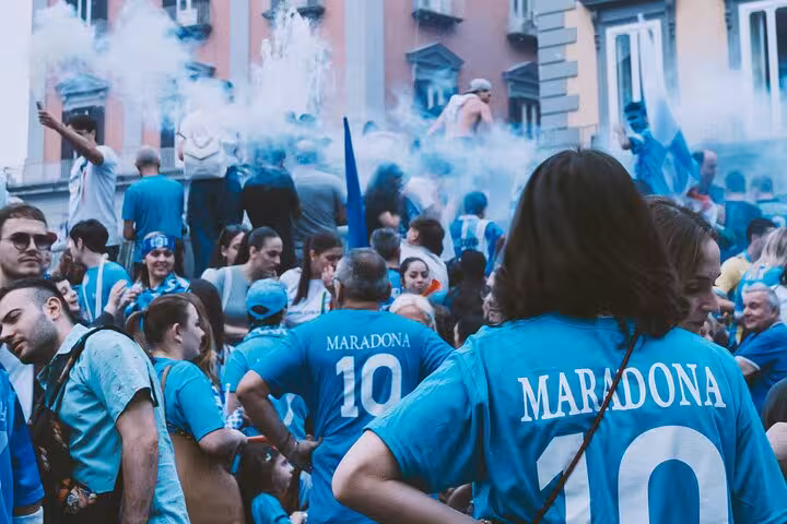 SCC Napoli fans in Maradona 10 jerseys celebrating with blue smoke before match in Naples with local
