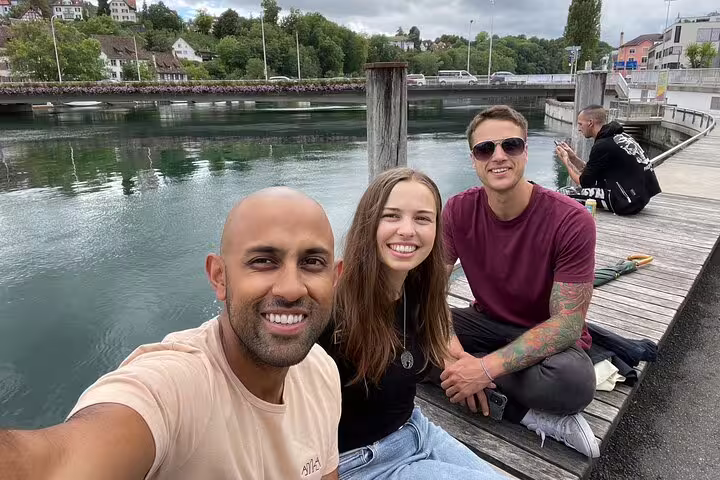 Travelers relaxing by the Rhine in Schaffhausen during a self-guided scavenger hunt, scenic waterfront stop