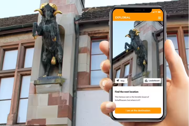 Phone shows Schaffhausen scavenger hunt app by ram statue landmark on self-guided city sights tour