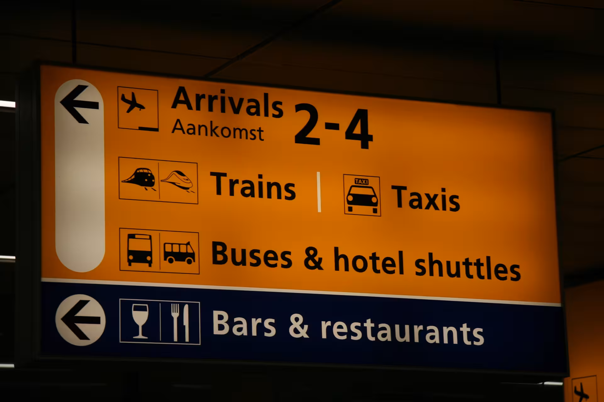 Schiphol Airport arrivals sign for trains, taxis and shuttles, ideal for Amsterdam private layover tour
