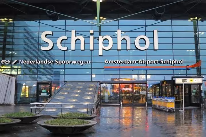 Schiphol Airport entrance sign in Amsterdam, private transfer pickup for direct ride to Brussels Belgium