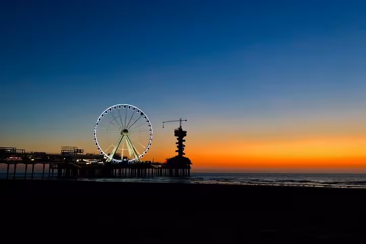 Scheveningen Pier Ferris wheel at sunset, scenic detour on Amsterdam or Schiphol Airport to The Hague transfer