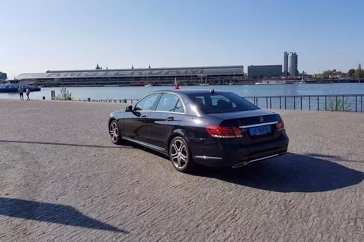 Luxury sedan for Schiphol Airport private transfer to Amsterdam with meet and greet, parked by waterfront