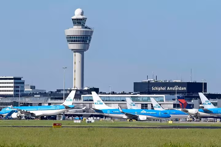 Schiphol Amsterdam Airport with KLM planes and control tower, pickup point for private transfer to Groningen