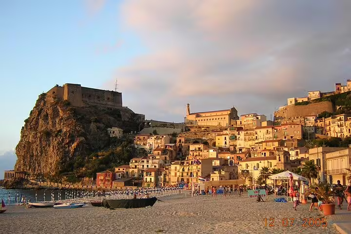 Golden hour view of Scilla beach, hillside houses and Castello Ruffo fortress visited on a private guided tour of Calabria