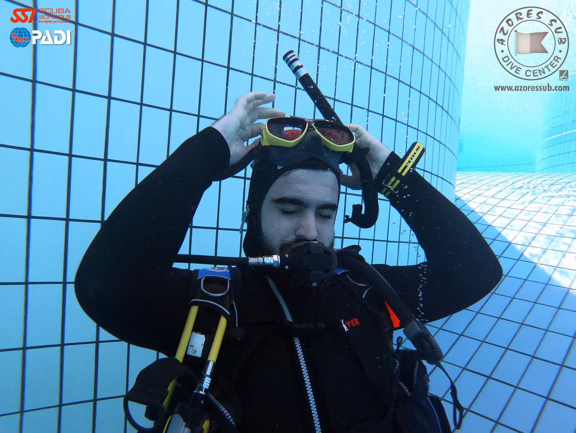 Scuba diver adjusting mask in a training pool during PADI open water course, perfect for beginner scuba lessons