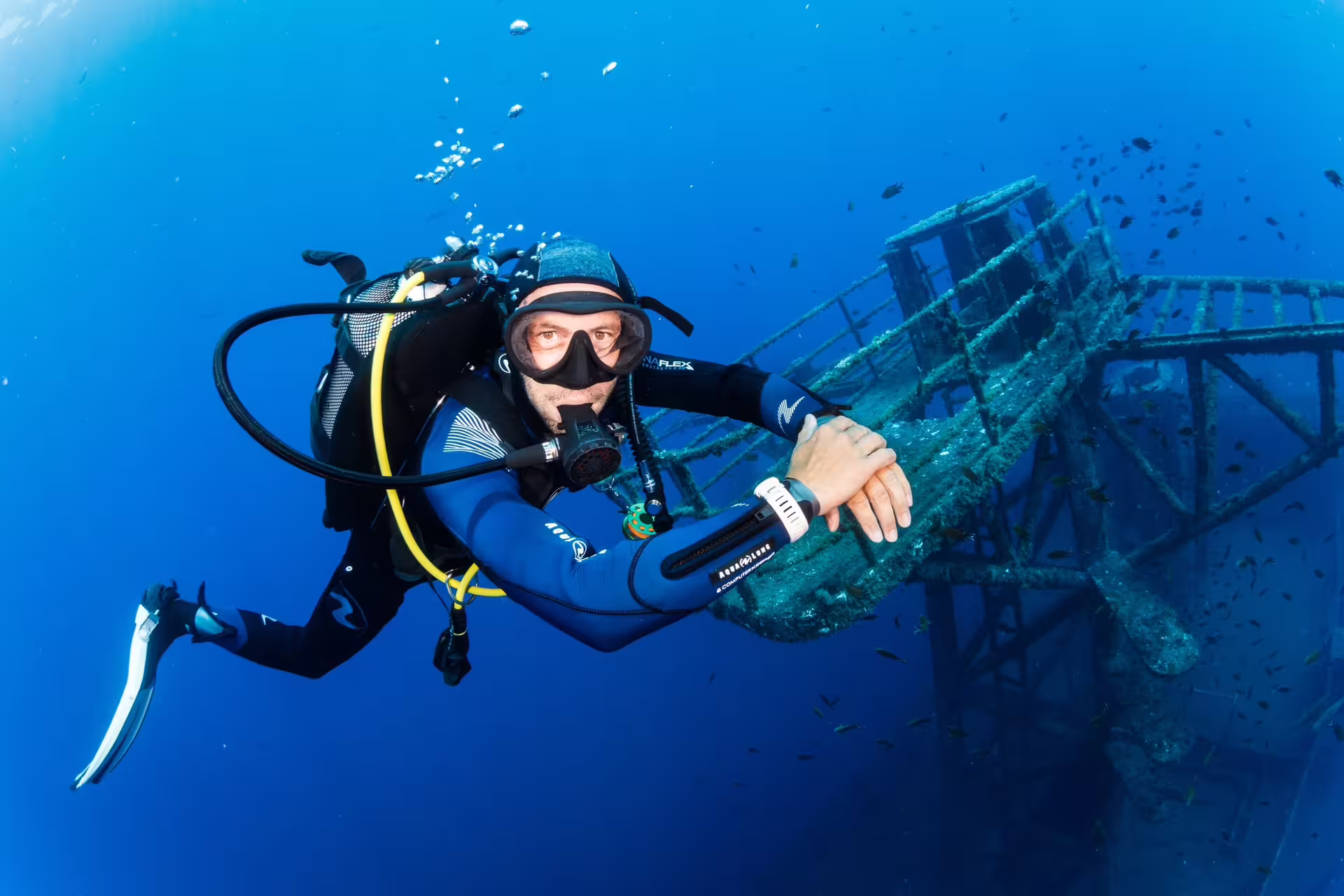 Scuba diver explores the vibrant marine life surrounding the sunken Wreck Corveta Afonso Cerqueira in the crystal-clear ocean.