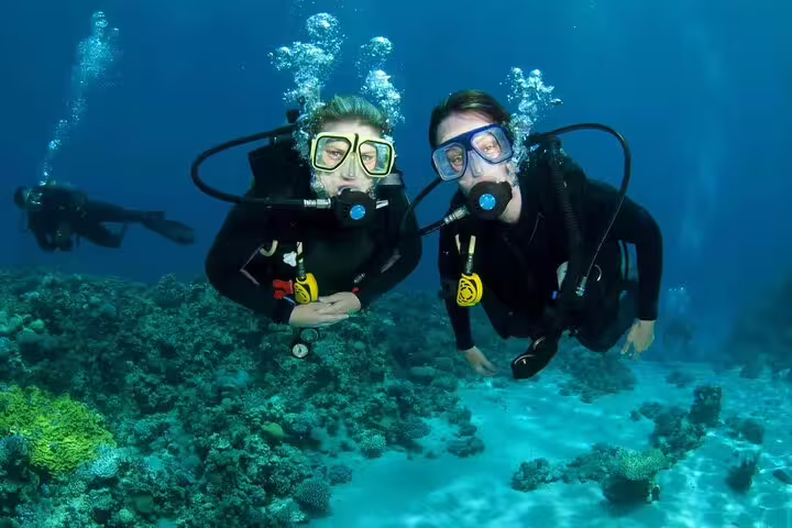 Two scuba divers over Red Sea reef on VIP boat diving and snorkeling day trip from Hurghada, Egypt