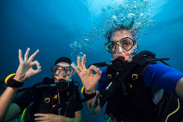 Underwater selfie of two scuba divers giving OK signs in Hurghada, Red Sea diving tour with lunch and transfer