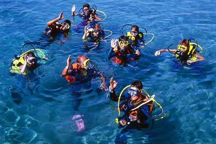 Group of scuba divers waving on the surface during a guided tour from Kusadasi, enjoying clear blue waters.