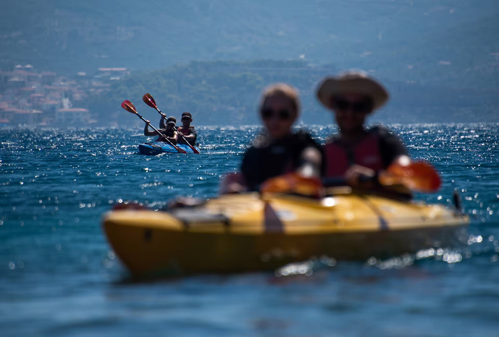 Sea kayakers paddling on Navarino Bay near Pylos, Messinia, Greece during a guided sea kayaking tour