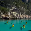 Groupe en kayak de mer sur eau turquoise dans les Calanques de Cassis, sortie guidée vers falaises et criques sauvages