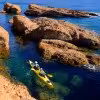 Kayak de mer dans les Calanques de Cassis, pagayage entre rochers dorés et eau cristalline sur la côte méditerranéenne
