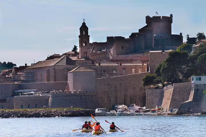Sea kayaking near Dubrovnik Old Town walls, small group paddling calm Adriatic waters on a coastal tour