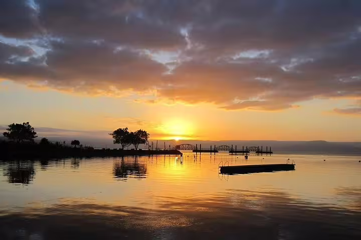 Sunset over the Sea of Galilee with pier reflections, scenic stop on private day trip from Tel Aviv