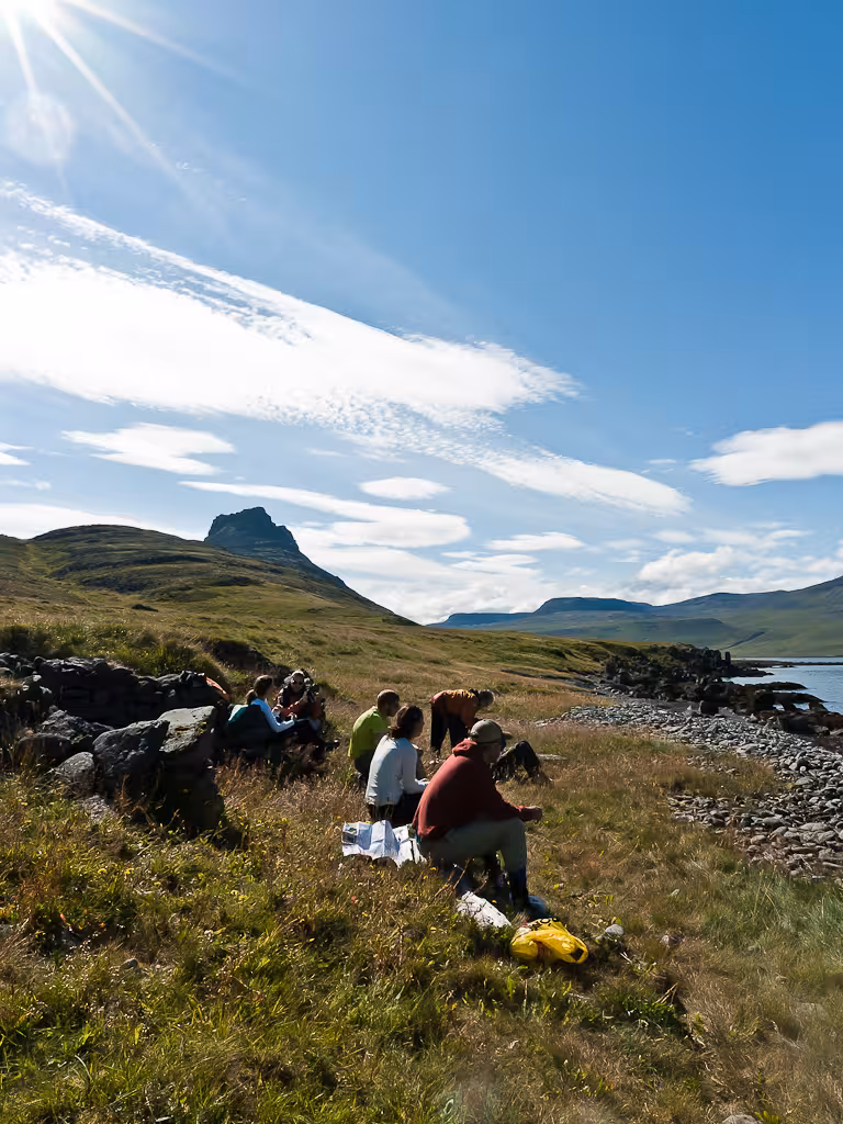 Small group birdwatching on coastal cliffs during Seabird Discovery tour with ocean views and mountains