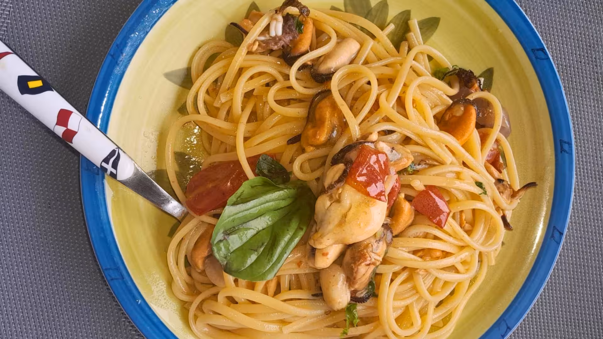 Delicious seafood pasta with mussels and cherry tomatoes served on a colorful plate during a La Maddalena tour.