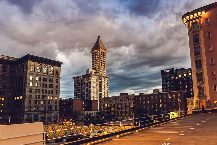 Historic Seattle downtown buildings with dramatic stormy sky, viewed from elevated parking lot at dusk