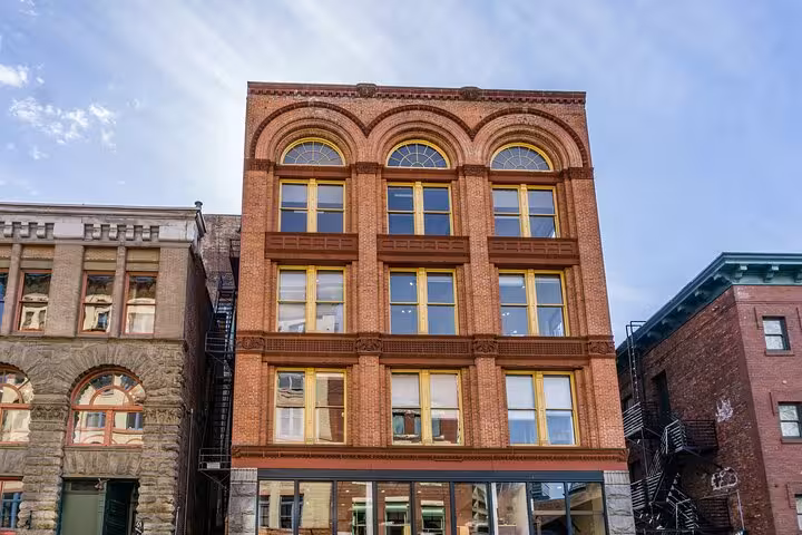 Historic red brick building with arched windows and yellow frames in Seattle's Pioneer Square district