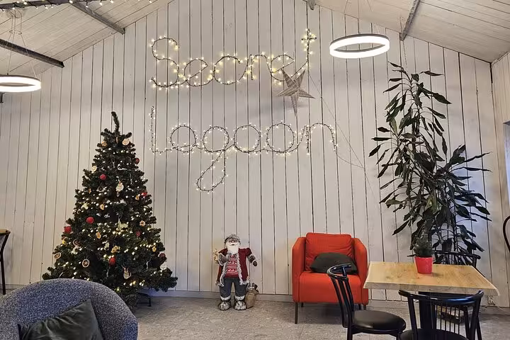Secret Lagoon interior decorated for Christmas with tree, Santa figure, red armchair, and fairy light sign