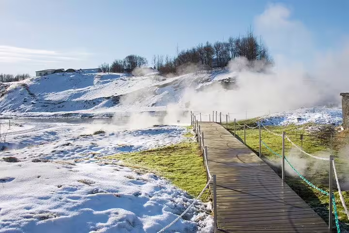 Steaming geothermal hot spring at Secret Lagoon surrounded by snow-covered landscape in Iceland winter
