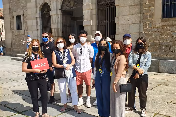 Tourists with masks explore Avila's historic architecture on a Segovia and Avila guided day tour from Madrid.