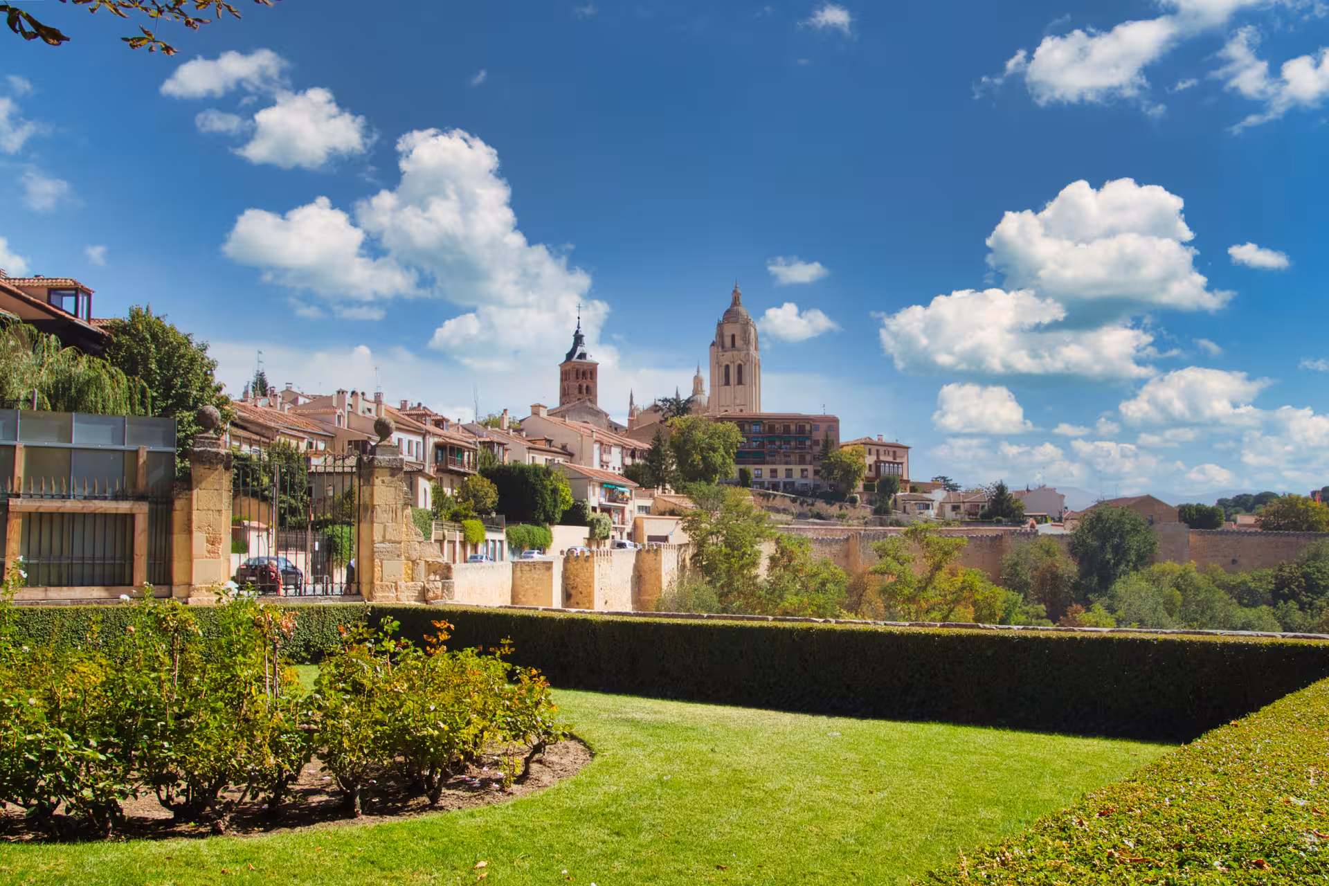 Scenic view of Segovia's cathedral and lush gardens, showcasing the city's architectural beauty from Madrid.