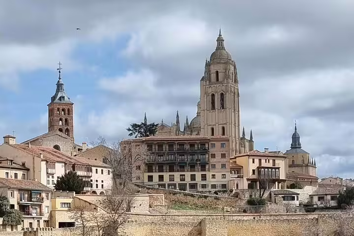 Segovia Cathedral skyline view on a private minivan tour from Madrid, historic old town under cloudy sky