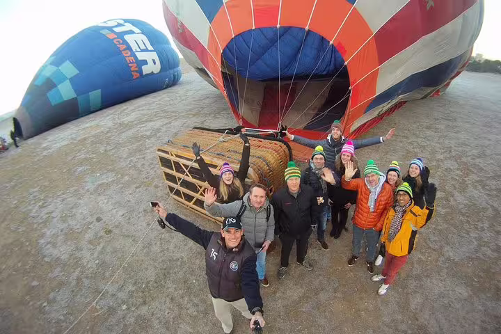 Group of people preparing for a scenic Segovia hot air balloon adventure with vibrant colors and excitement.