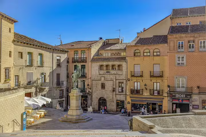 Segovia Plaza Mayor with statue and historic facades, a stop on a private Segovia minivan tour from Madrid