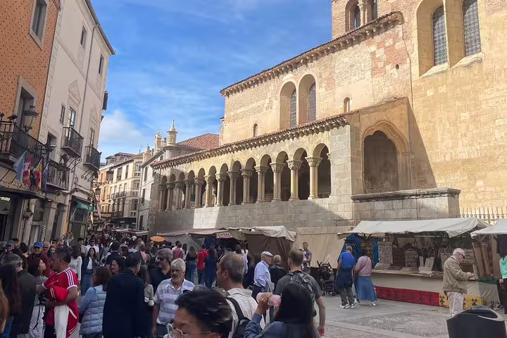 Segovia Plaza Mayor market crowd beside San Martín church on a half-day private Segovia minivan tour