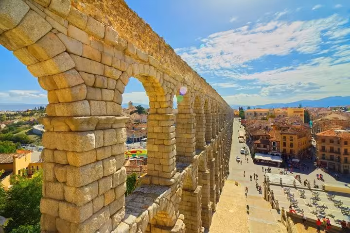 Majestic Roman Aqueduct in Segovia under a bright blue sky, highlighting historic architecture on a day tour from Madrid.