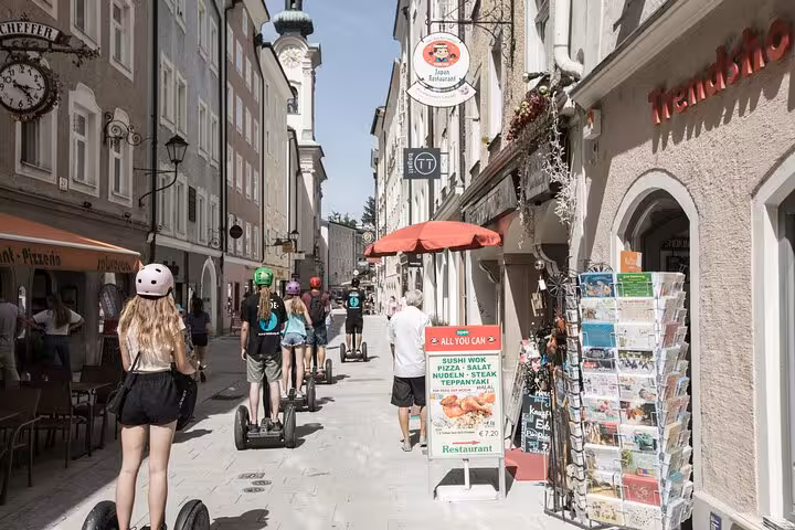 Group on Segways exploring Salzburg's charming old town streets lined with shops and cafes.