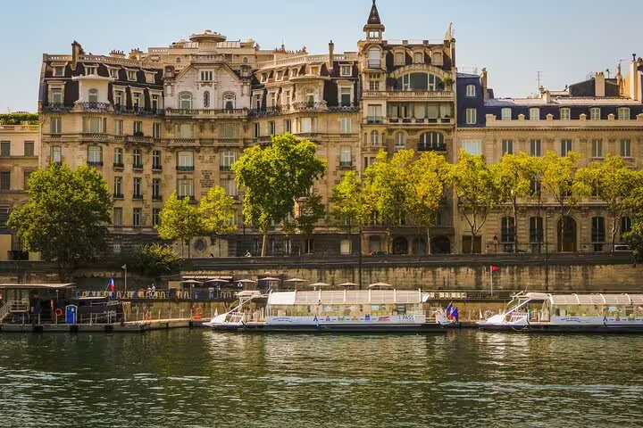Seine River cruise boat docked along Haussmann-style buildings on Paris riverbank