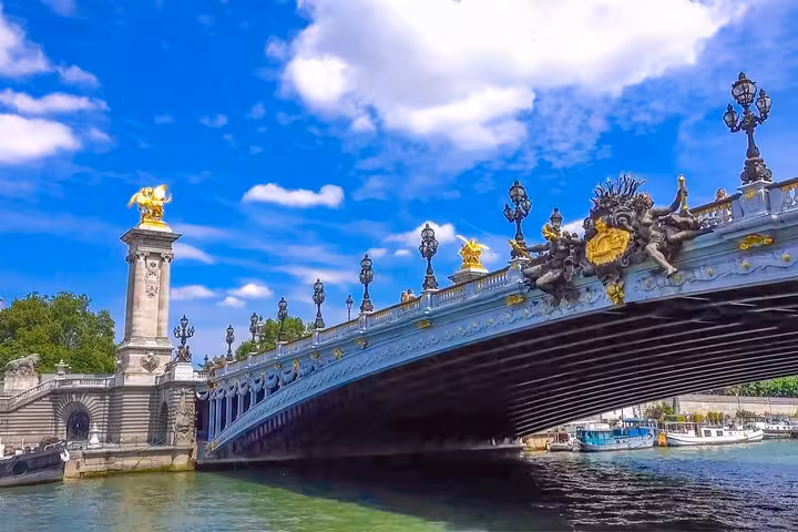 Seine River cruise under ornate Pont Alexandre III bridge, a scenic stop on Paris highlights walking tour